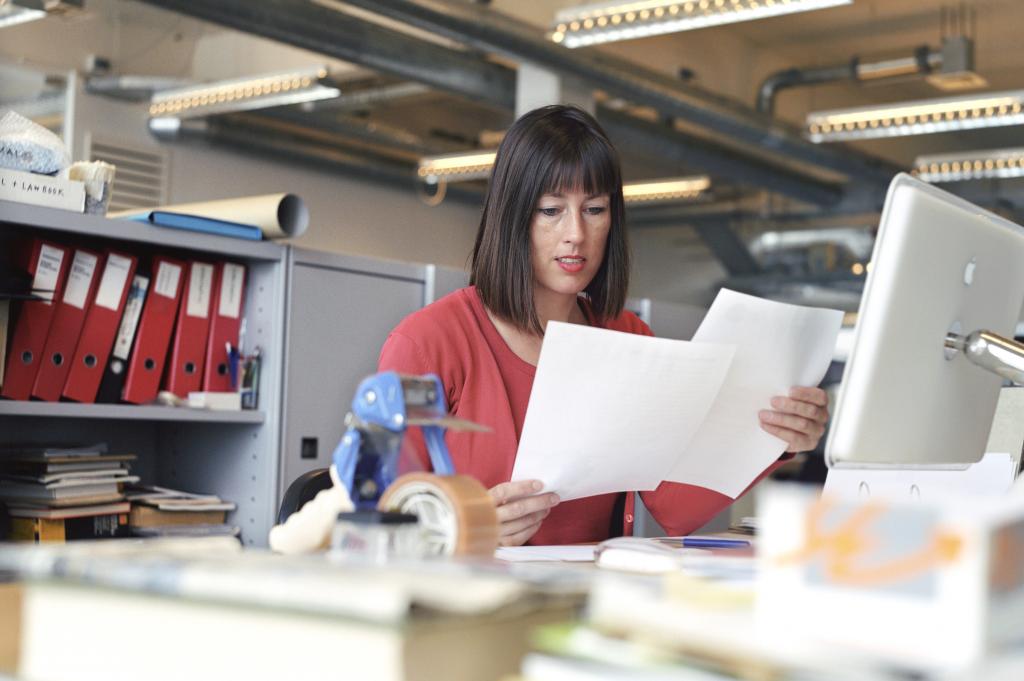 Vrouw op kantoor achter laptop, bezig met de administratie